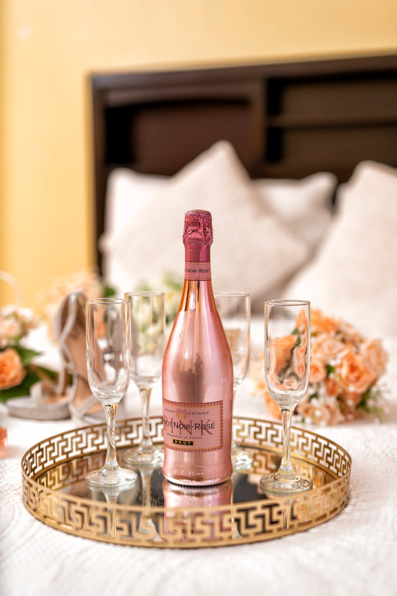 Rosé sparkling wine and glasses on a mirrored tray